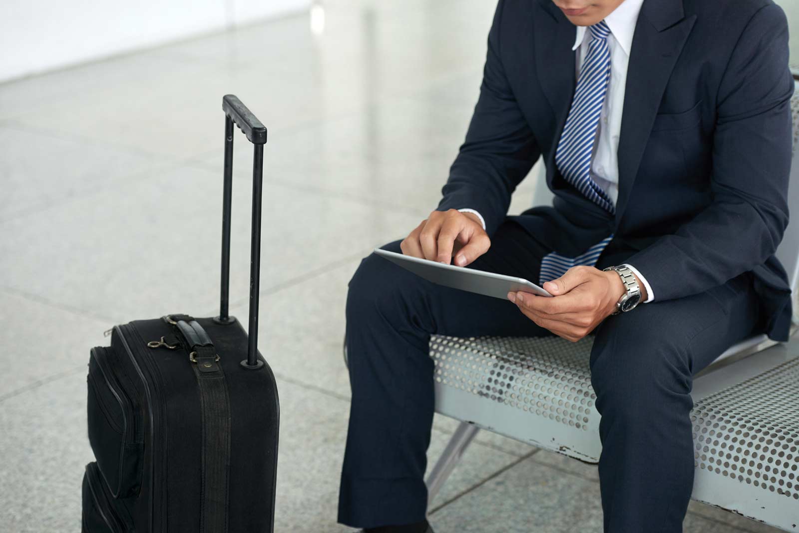 Homem de negócios usando o tablet no aeroporto