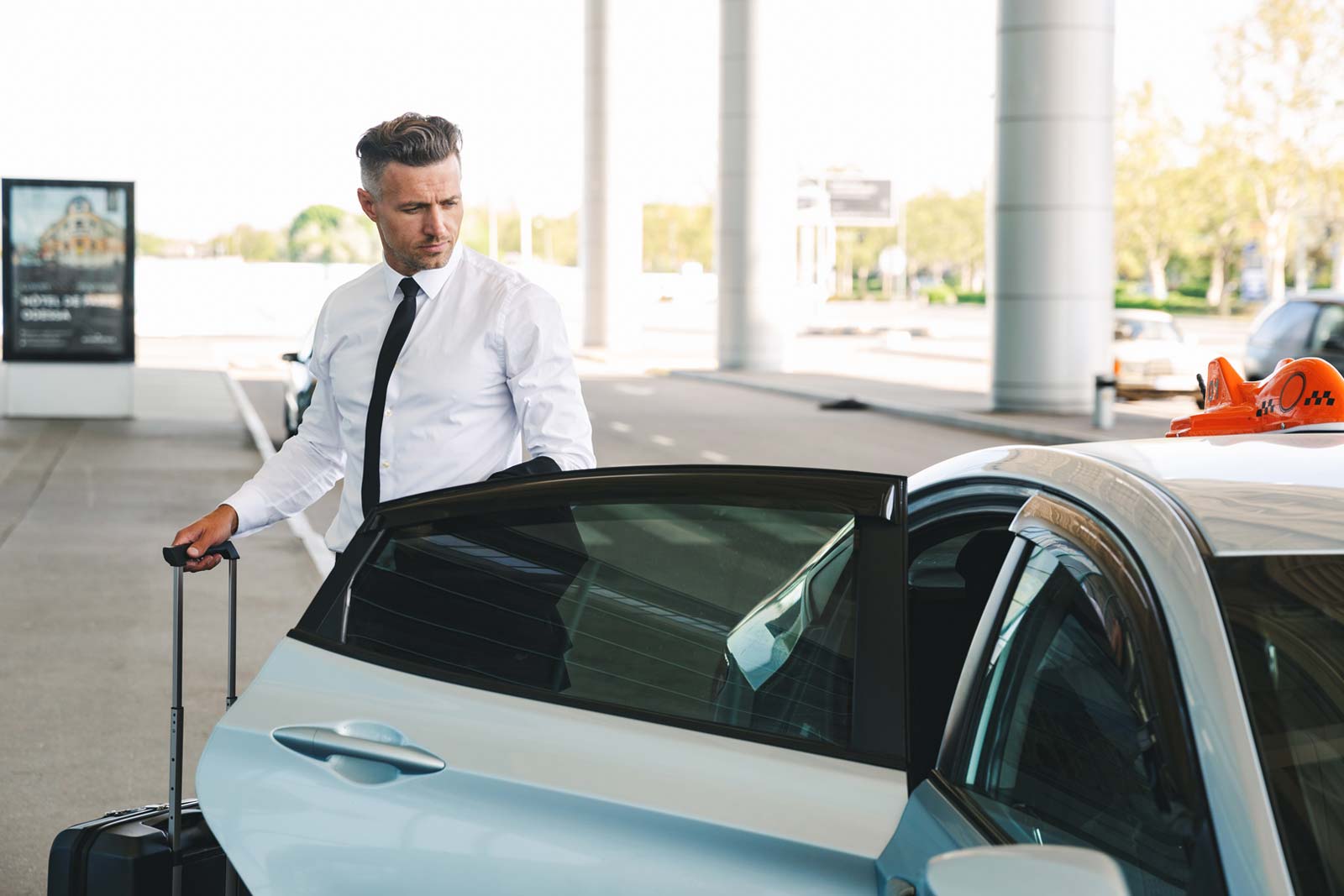 Businessman getting in taxi at the airport