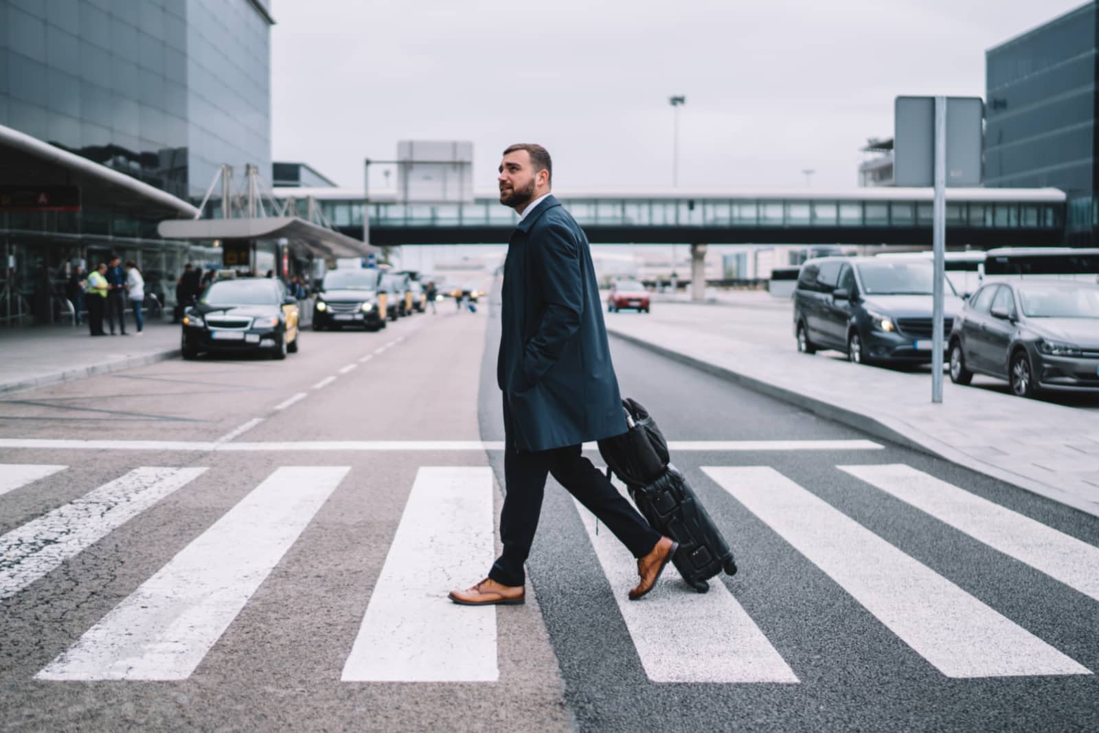 Businessman at the airport with a suitcase and a backpack with a strap